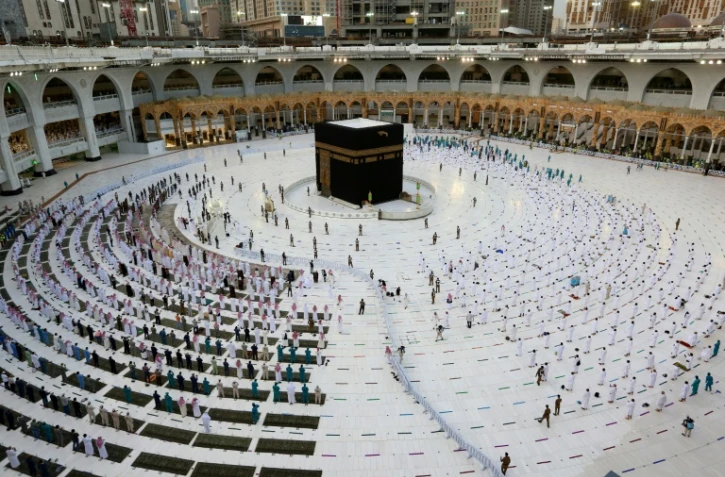 Des fidèles rassemblés autour de la Kaaba, dans la grande mosquée de La Mecque, le 13 mai 2021. L'arabie saoudite a annoncé ce même jour que 60.000 résidents vaccinés seraient autorisés cette année à effectuer le Hajj, le grand pélerinage qui accueille habituellement 2,5 millions de personnes