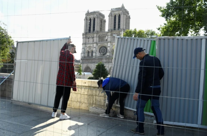 Des ouvriers installent des palissades le 13 août 2019, près de Notre-Dame de Paris en vue de la décontamination des rues alentour de la cathédrale
