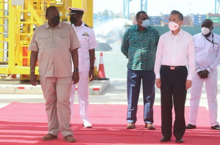 Le président kényan Uhuru Kenyatta (G) et le ministre chinois des Affaires étrangères Wang Yi (D) visitent le 6 janvier 2022 un nouveau terminal portuaire à Mombasa, au Kenya, financé par la Chine