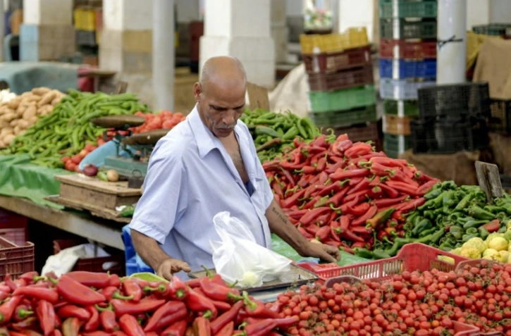 Un marchand pèse des produits sur un étal au marché populaire de Bab el-Fellah, à Tunis, le 28 juillet 2021