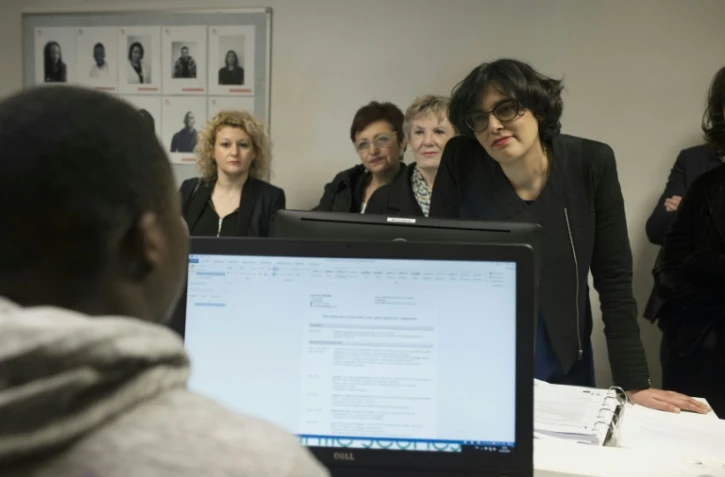 La ministre du Travail Myriam El-Khomri discute avec un jeune qui participe au programme "Garantie Jeunes" le 12 avril 2016 à Paris