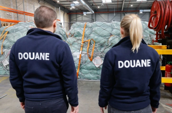 Des douaniers devant des colis de fret aérien dans un entrepôt de l'aéroport Roissy-Charles-de-Gaulle, au nord de Paris, le 29 avril 2025