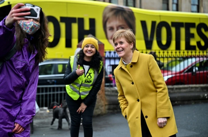 La Première ministre écossaise Nicola Sturgeon (D) pose le 6 mai 2021 à Glasgow, devant un bureau de vote