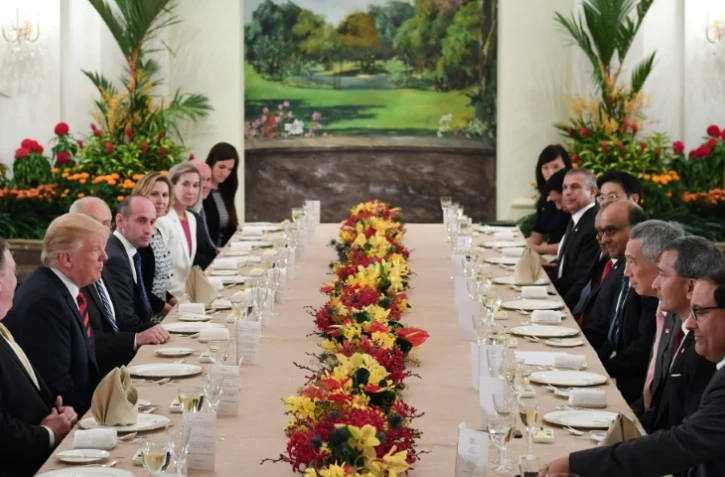 Le président Donald Trump (2e g) et la délégation américaine lors d'un déjeuner de travail avec le Premier ministre singapourien Lee Hsien Loong (3e d), le 11 juin 2018 à l'Istana