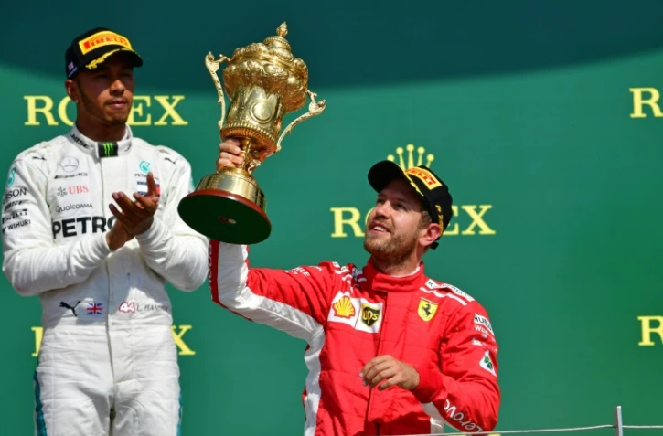 Sur le podium, le pilote britannique Lewis Hamilton applaudit son rival Sebastian Vettel, vainqueur du GP de Grande-Bretagne à Silverstone, le 8 juillet 2018