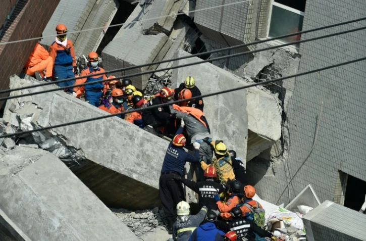 Des secouristes recherchent des survivants dans les décombres d'un immeuble le 7 février 2016, à Tainan, dans le sud de Taïwan, au lendemain d'un séisme de magnitude 6,4