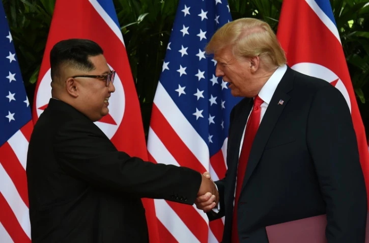 Le leader nord-coréen Kim Jong Un (g) serre la main au président américain Donald Trump (d) avant le début du sommet historique à l'hôtel Capella, le 12 juin 2018 à Singapour