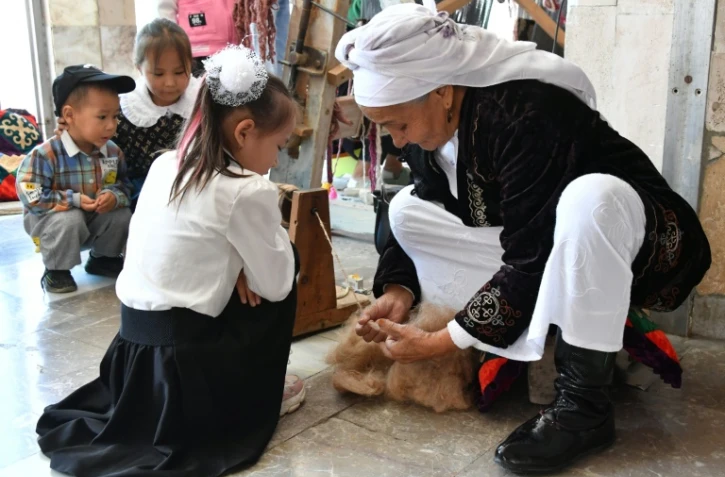 Tachkan Khakimova tisse un tapis traditionnel kirghiz, le chyrdak, le 2 octobre 2023 à Kadamjaï au Kirghizstan
