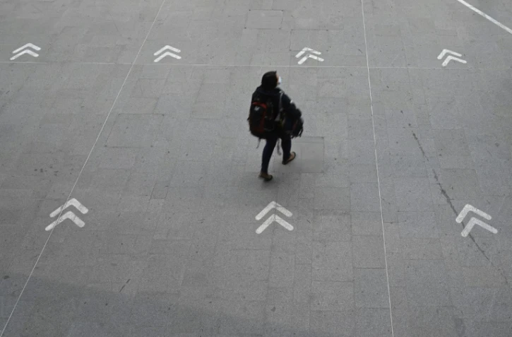 Une passagère à la gare de Rennes (ouest de la France), où des marquages au sol indiquent les distances à respecter entre les personnes, le 19 mars 2021