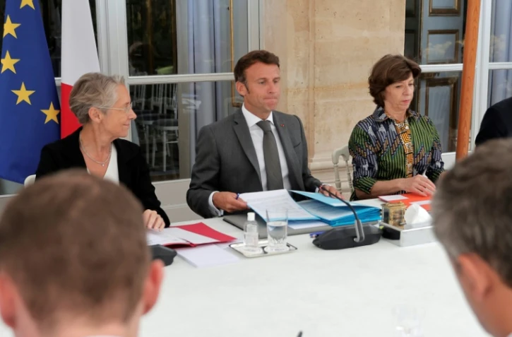 Le président Emmanuel Macron, la Première ministre Elisabeth Borne (g) et la ministre des Affaires étrangères Catherine Colonna (d) à l'Elysée, le 25 juillet 2022 à Paris