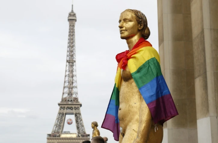 Un drapeau arc-en-ciel posé sur les épaules d'une statue sur le parvis des droits de l'Homme à Paris, le 13 juin 2016