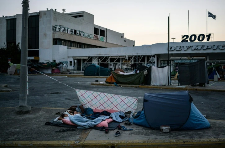 Des migrants dorment près de l'aéroport international d'Athènes le 10 août 2016
