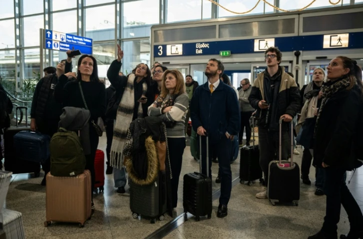 Des voyageurs attendent à l'aéroport d'Athènes-Spata après des retards et des reports de vols dans le pays dus à un "problème technique", le 4 janvier 2026