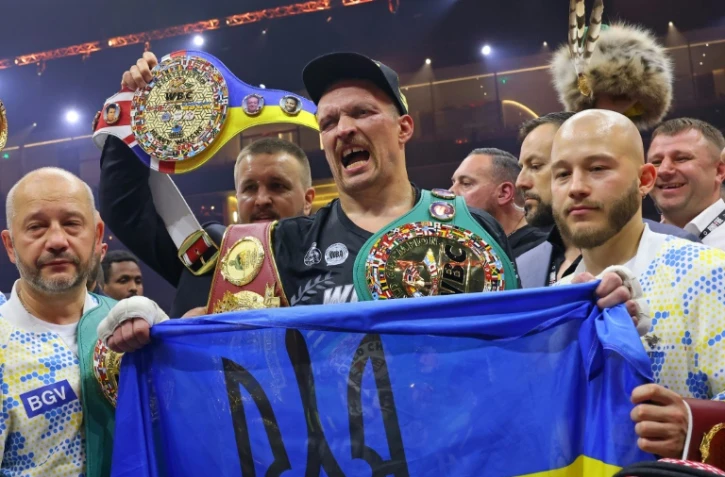 Oleksandr Usyk célèbre avec un drapeau ukrainien sa victoire sur Tyson Fury dans le championnat du monde des lourds à Riyadh, le 19 mai 2024.
