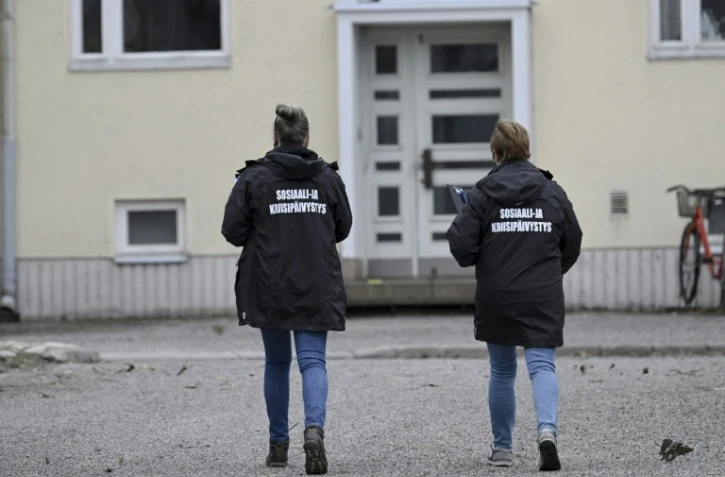 Deux membres d'une cellule de crise devant l'école primaire de Vantaa, en Finlande, où un enfant a ouvert le feu, blessant trois élèves le 2 avril 2024