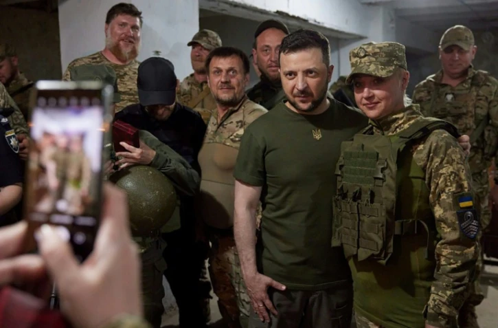 Le président ukrainien Volodymyr Zelensky posant avec une militaire à Mykolaïv, le 18 juin 2022