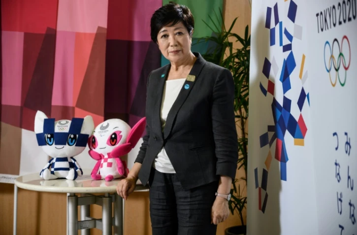 La gouverneure de la capitale japonaise Yuriko Koike pose aux côtés des mascottes des Jeux de Tokyo, Miraitowa (à gauche) et Someity (à droite), avant un entretien avec l'AFP le 12 juin 2020.
