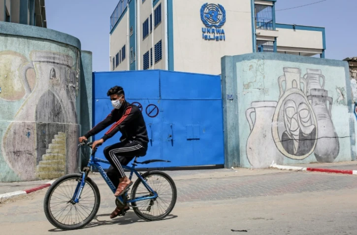 Un palestinien circule en vélo devant les portes fermées d'une école gérée par l'Agence de l'ONU pour les réfugiés palestiniens (Unrwa) à Rafah, le 6 avril 2021