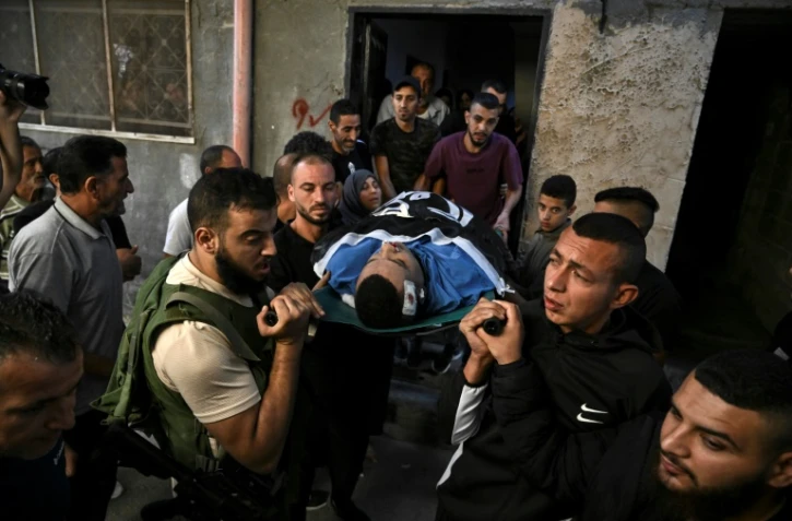 Des Palestiniens portent le corps drapé d'un homme tué lors d'un raid israélien, dans le camp de réfugiés de Jénine, en Cisjordanie occupée, lors de ses funérailles, le 10 novembre 2023