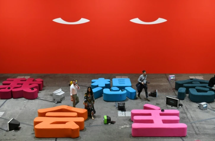 Des visiteurs marchent au milieu de l'oeuvre d'art de Nedko Solakov le 12 juin 2018 à Art Basel, à Bâle en Suisse