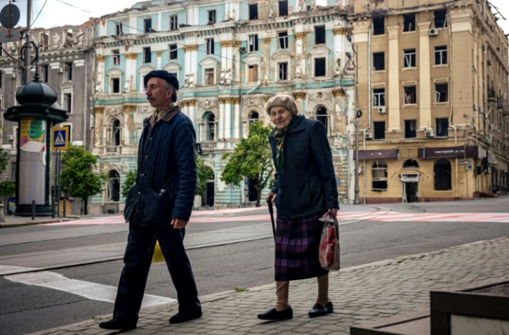 Des passants dans l'ancienne "avenue de Moscou", rebaptisée "Héros de Kharkiv" dans l'est de l'Ukraine, le 23 mai 2022