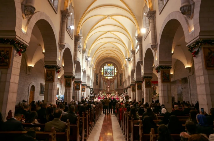 Le patriarche latin de Jérusalem Pierbattista Pizzaballa (C) dirige la messe de Noël à l'église de la Nativité dans la ville de Bethléem en Cisjordanie occupée, le 24 décembre 2024