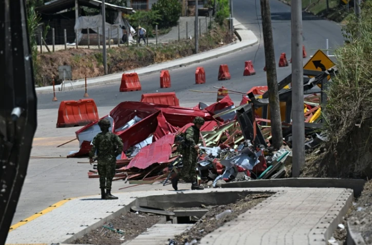 Des soldats se tiennent près des restes d'un péage en construction détruit par une explosion à Santander de Quilichao, en Colombie, le 8 août 2026