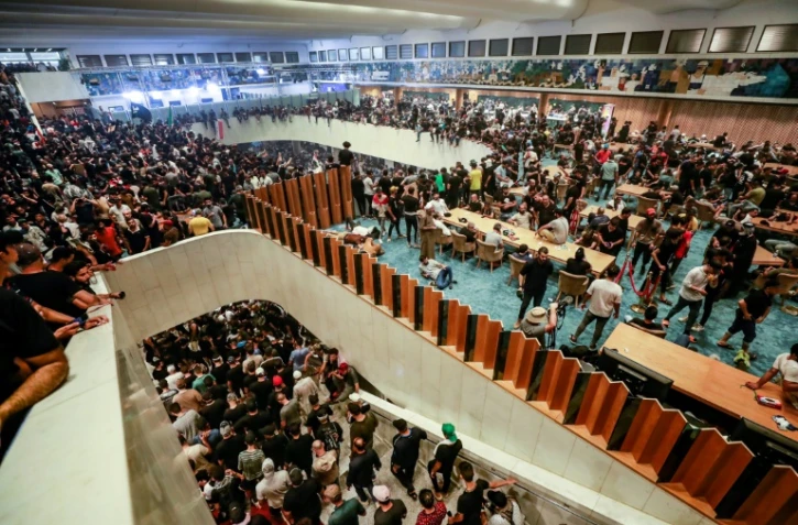 Des partisans de l'influent leader politique chiite Moqtada Sadr s'apprêtent à passer leur première nuit au Parlement que des milliers de manifestants ont envahi, à Bagdad le 30 juillet 2022 