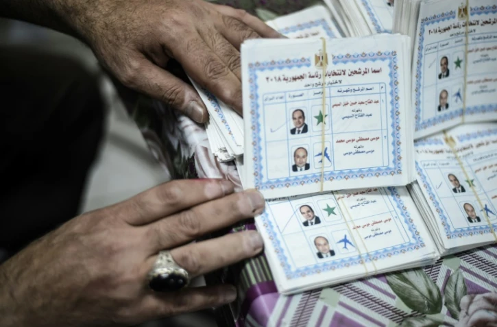 Le responsable d'un bureau de vote compte les bulletins le 28 mars 2018 au Caire (Égypte)