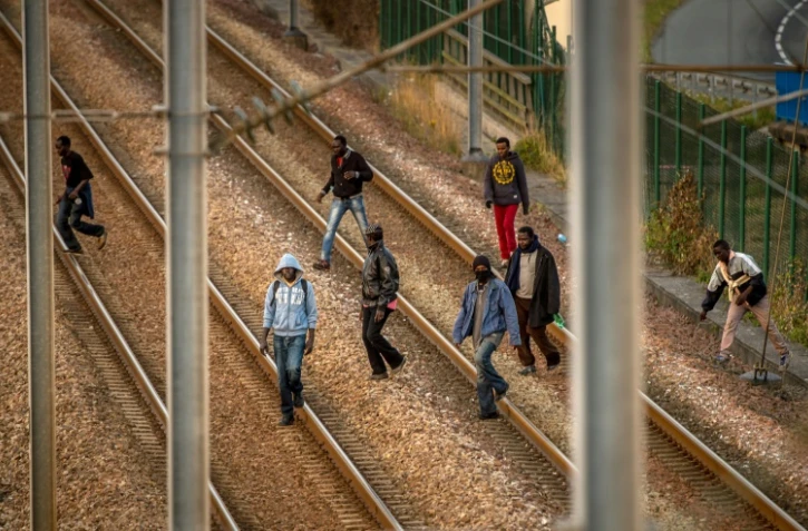 Des migrants sur les rails du site d'Eurotunnel à Coquelles, le 12 août 2015
