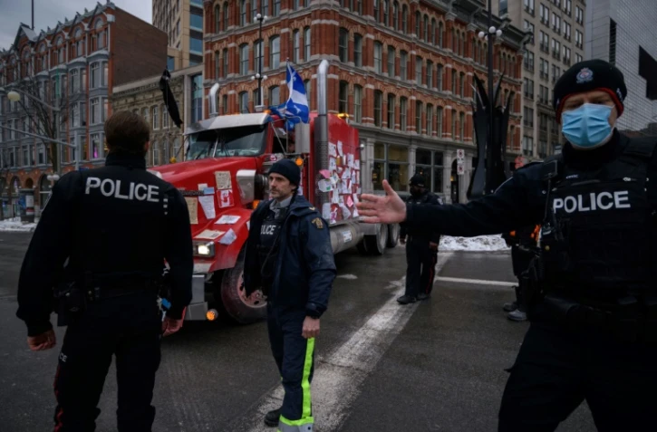 Des policiers encerclent un camion qui quitte une manifestation devant le Parlement à Ottawa (Canada), le 16 février 2022