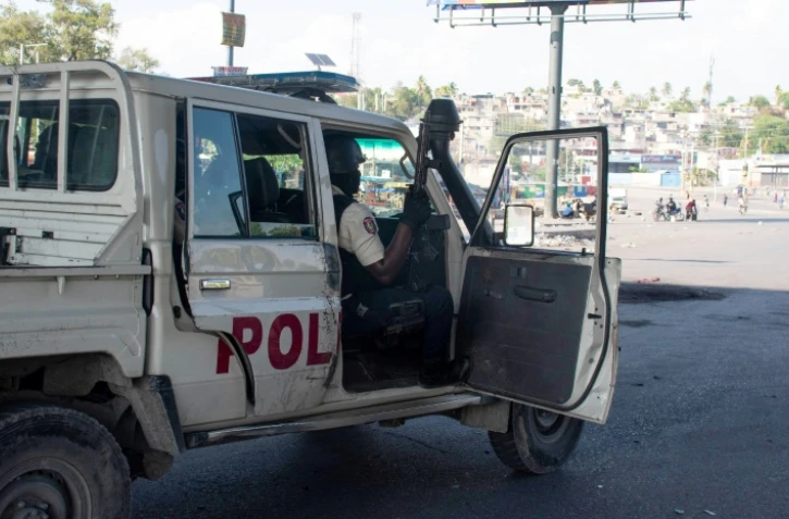 Des policiers contrôlent le périmètre d'un commissariat incendié la veille par des gangs armées, à Port-au-Prince, en Haïti, 6 mars 2024