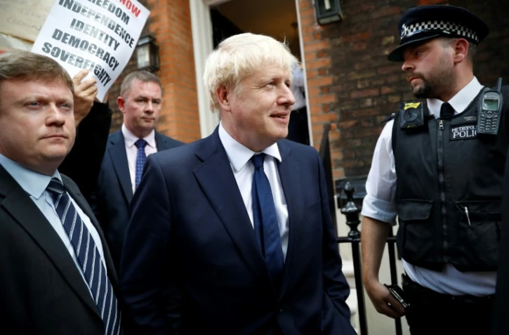 Boris Johnson (c) sort de son quartier général de campagne, le 22 juillet 2019 à Londres