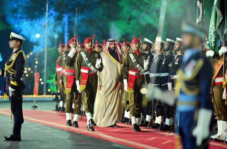 Photographie prise et diffusée le 17 février 2019 par le Département de l'information du Pakistan (PID) montrant le prince héritier saoudien Mohammed ben Salmane (C) accueilli par une garde d'honneur chez le Premier ministre à Islamabad