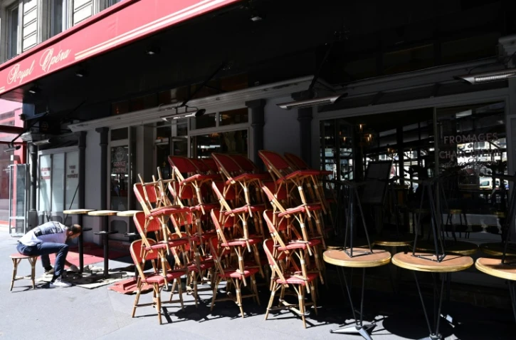 Un employé installe des tables et des chaises avant la réouverture des terrasses des cafés, bars et restaurants, le 30 mai 2020 à Paris
