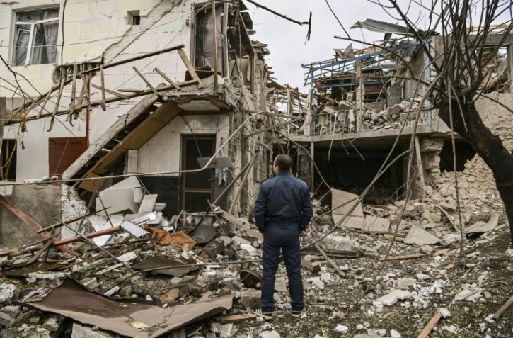 Un policier devant une habitation détruite dans les bombardements à Stepanakert, la capitale du Nagorny Karabakh,  le 7 octobre 2020.