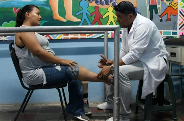 Walter Aguilar (D), lui même amputé de la jambre droite après un accident de circulation en 2001, s'est spécialisé dans la fabrication de prothèses de polypropylène