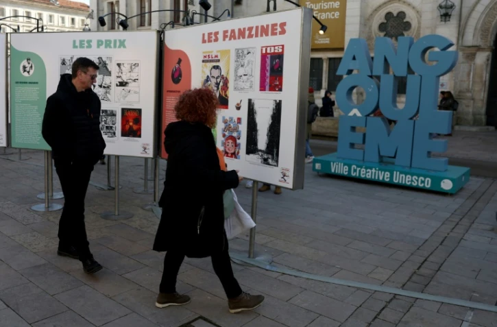 Des visiteurs regardent des affiches dans le cadre d'une exposition lors du 52e Festival international de la bande dessinée d'Angoulême, le 30 janvier 2025