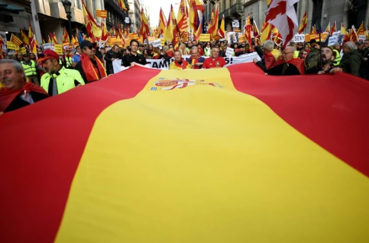 Des manifestants portent un drapeau espagnol lors d'une manifestation contre l'indépendance de la Catalogne à Barcelone, le 6 décembre 2017
