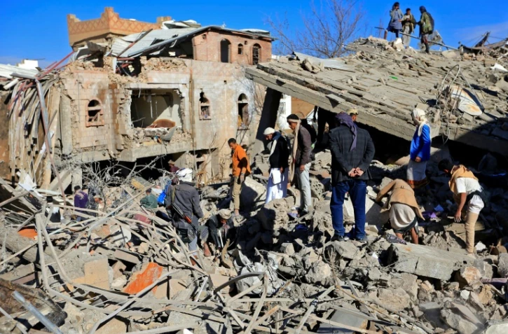 Des Yéménites inspectent les décombres après des frappes de la coalition militaire dirigée par l'Arabie saoudite sur Sanaa, dirigée par les Houthis, le 18 janvier 2022