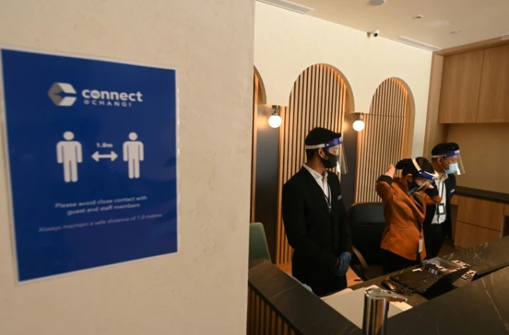 Le personnel est debout derrière la réception du Connect@Changi, présenté comme le premier hôtel et centre de conférences sécurisé contre le Covid-19, le 18 février 2021 à Singapour