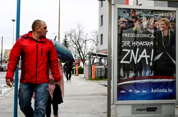 Un Croate regarde une affiche de la présidente Kolinda Grabar-Kitarovic, candidate à sa propre réelection, le 21 décembre 2019 à Zagreb