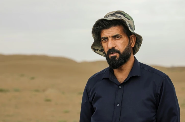 L'archéologue irakien Aqeel Mansarawi lors d'une interview sur le site archéologique d'Umm al-Aqarib, fréquemment enseveli par des tempêtes de sable dues à la désertification, dans la province irakienne de Dhi Qar le 31 mars 2023