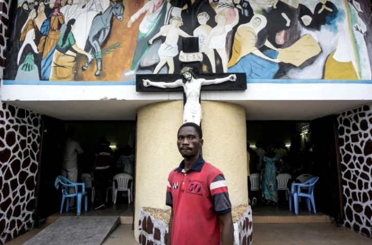 Un Congolais devant une église où se tient une messe avant une manifestation contre le maintien au pouvoir du président Joseph Kibila, le 21 janvier 2018 à Kinshasa