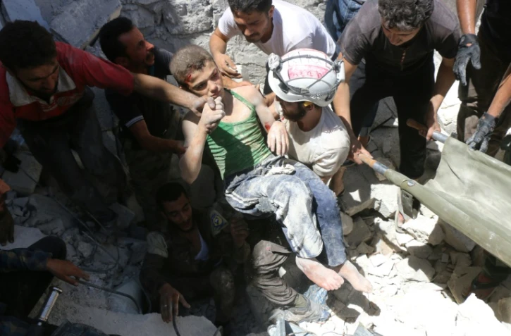Un adolescent extrait des décombres lors de raids aériens le 25 juillet 2016 sur Alep
