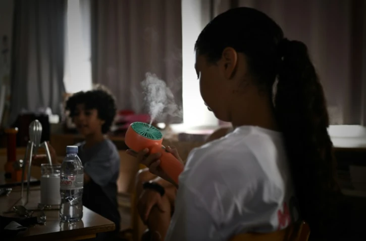 Une enfant se rafraîchit dans une salle de classe en école élémentaire, à Bordeaux dans le sud-ouest de la France, le 1er juillet 2025