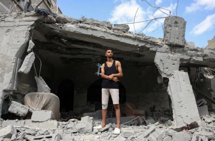 L'étudiant palestinien blessé Fares al-Farra, 19 ans, sur les décombres de sa maison, détruite par les bombardements israéliens, à Khan Yunis, dans le sud de la bande de Gaza, le 16 septembre 2024