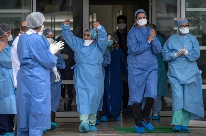 Des personnels soignants applaudissent la sortie de patients guéris du Covid-19, le 12 avril 2020 à Rabat, au Maroc