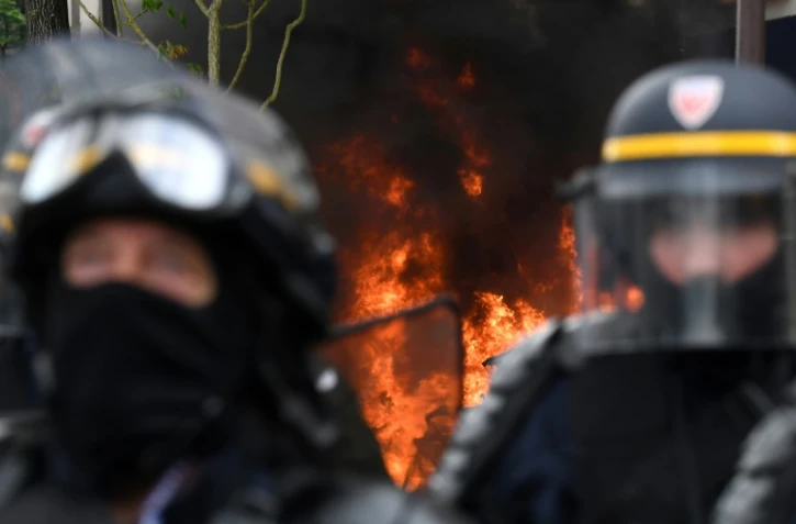 Des CRS devant un incendie en marge de la manifestation du 1er Mai à Paris