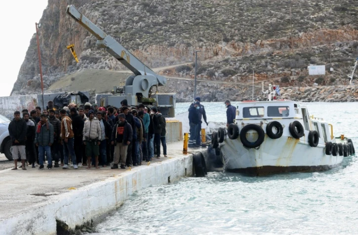 Des migrants débarquent d'un bateau au port de Kali Limenes, à Héraklion, dans le sud de la Crète, le 21 février 2026